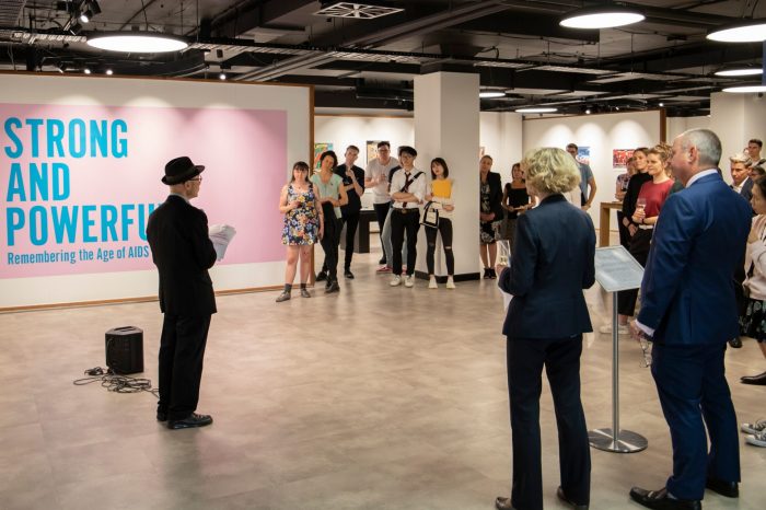 Opening event crowd amongst exhibition installation watching speeches