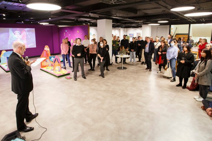 Shane Simpson speaking in front of a semi-circle crowd of approximately 60 guests.