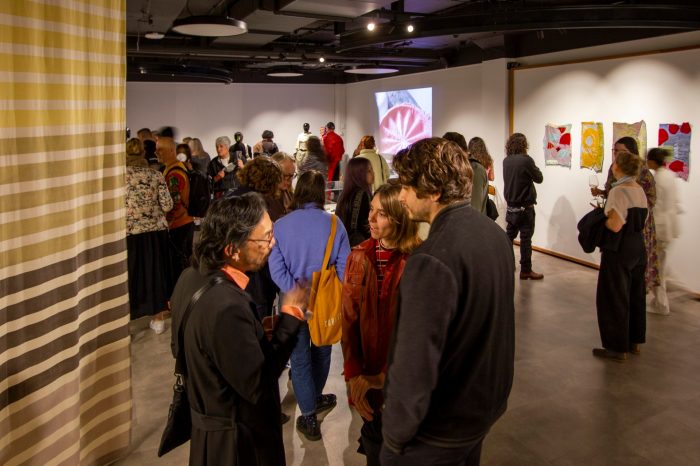 A gallery space filled with people socialising.